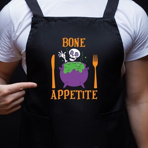 May include: Black apron with a skeleton in a cauldron and the text "BONE APPETITE" in orange.