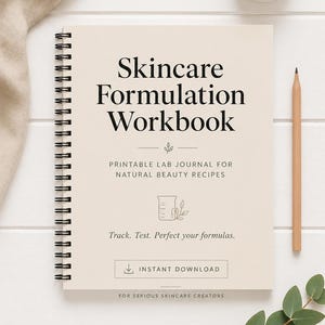 May include: A spiral-bound workbook titled "Skincare Formulation Workbook" with the text "Printable Lab Journal for Natural Beauty Recipes." A pencil and a jar of cream are next to the workbook. The image also includes the text "Track. Test. Perfect your formulas."