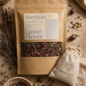 Könnte beinhalten: Ein brauner Papiersack mit "Lunar Bloom" Kräuterbadetee, mit einem transparenten Fenster, das die lose Mischung aus Kräutern und Blumen zeigt. Ein kleiner Musselinbeutel mit dem Logo "SherJaan Botanica" befindet sich neben dem Beutel. Getrocknete Blumen und Kräuter sind verstreut.