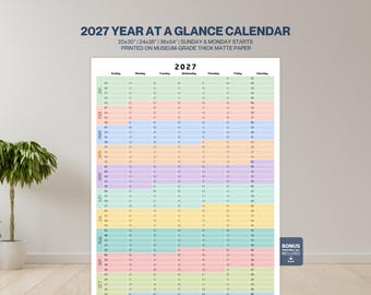 May include: A 2027 year at a glance wall calendar printed on thick matte paper. The calendar features a grid layout with months colour-coded in horizontal rows, displaying days of the week and dates. Text includes 2027 YEAR AT A GLANCE CALENDAR.
