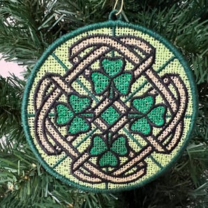 May include: A green, black, and beige round Christmas ornament with a Celtic knot design and shamrocks.