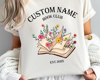 May include: White t-shirt with a floral book design and the text "CUSTOM NAME BOOK CLUB EST. 2025".