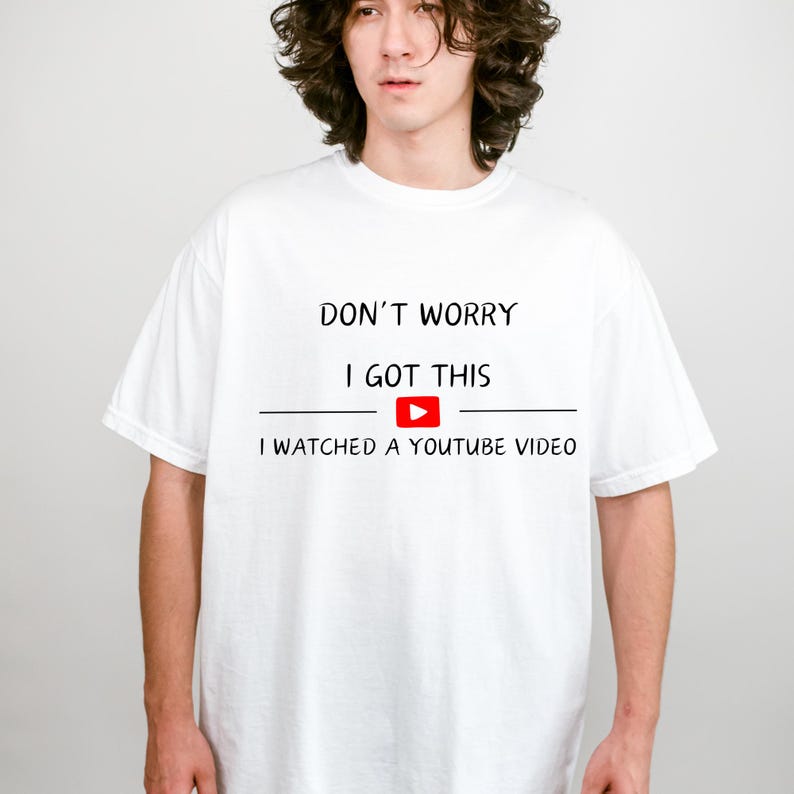 May include: White t-shirt with the text "DON'T WORRY I GOT THIS" above a YouTube play button and the phrase "I WATCHED A YOUTUBE VIDEO". The shirt is a casual, short-sleeved style.