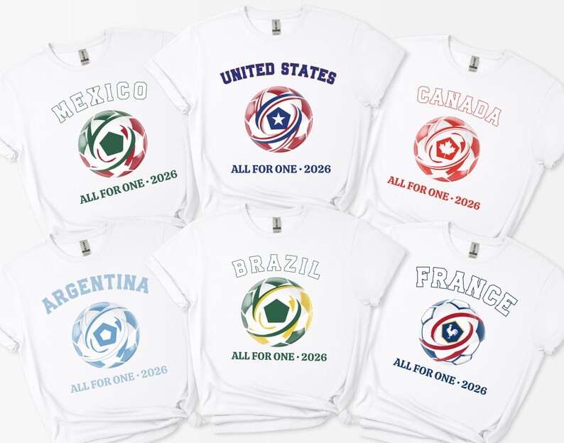 May include: White t-shirts featuring soccer ball designs with country names and "ALL FOR ONE - 2026". Countries include Mexico, United States, Canada, Argentina, Brazil, and France. Each ball has a unique color scheme.