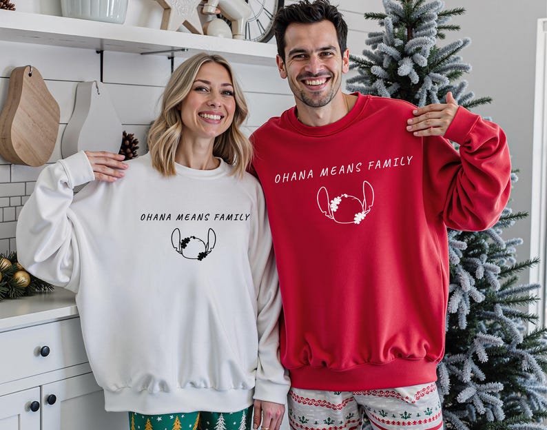 May include: A couple wearing matching sweatshirts, one white and one red. Both sweatshirts feature the text "OHANA MEANS FAMILY" and a Stitch graphic. The sweatshirts are part of a family matching set, perfect for Christmas or family gatherings.