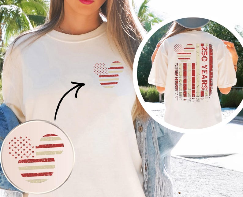May include: Cream-coloured t-shirt featuring a patriotic Mickey Mouse design on the front and back. The design incorporates red and white stripes and stars, with the text "250 YEARS" on the back. The shirt has a relaxed fit.