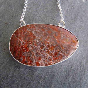 Pendant of Red Dinosaur Bone and Sterling Silver with Dino Cutout