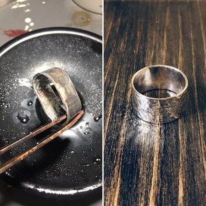 May include: A silver ring with a hammered texture. The ring is shown in two stages: being worked on with tools in a black bowl and finished on a wooden surface. The ring has a wide band design.