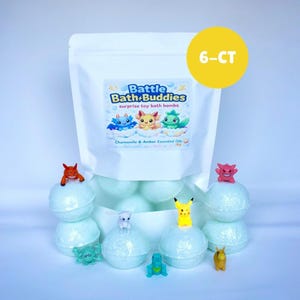 以下が含まれることがあります： 「Battle Bath Buddies」のサプライズおもちゃバスボムが入った白いバッグ。黄色の6-CTステッカー付き。バスボムは水色で、小さなフィギュアが上に乗っています。バッグのラベルには漫画のキャラクターと「Chamomile & Amber Essential Oils」の文字が描かれています。