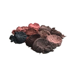 May include: A close-up of a pile of loose eyeshadow powder in various shades of brown, pink, and black.