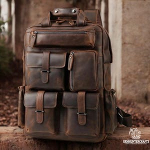May include: A brown leather backpack with multiple pockets and buckles. The backpack has a distressed look and is made of high-quality leather.