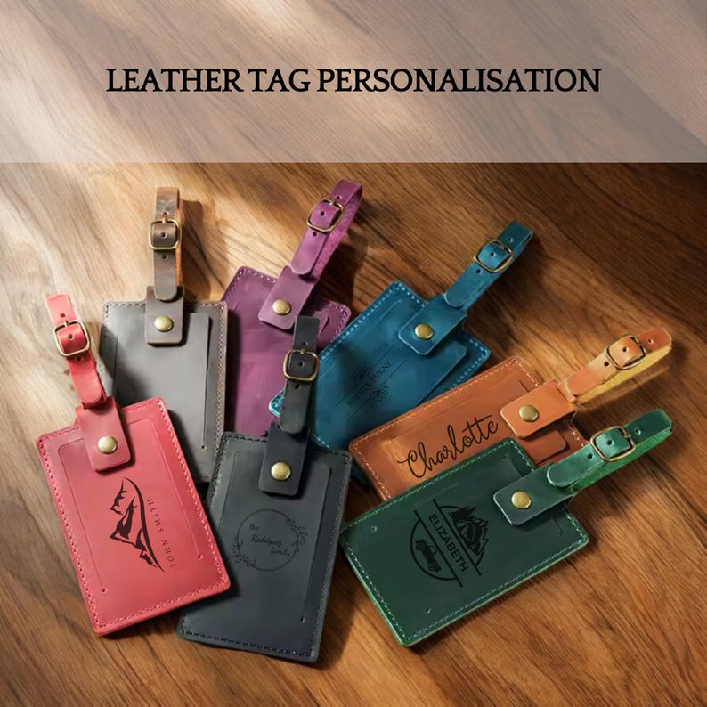 May include: A collection of six personalized leather luggage tags in various colors, including red, purple, blue, green, brown, and black. Each tag features a different design and text, such as "Charlotte", "Elizabeth", and "The Ridgeway Farm".