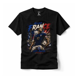 May include: A black short-sleeved t-shirt featuring a graphic of a football player in a blue jersey with the number 10, holding a football. The design includes the text "ALLEZ FRANCE", "LES BLEUS", and "2026 WORLD CUP" with the Eiffel Tower.