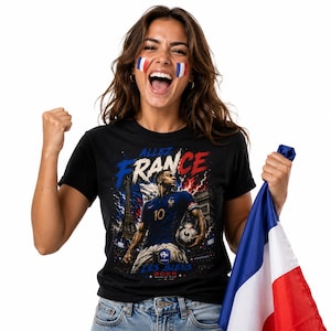 May include: A black t-shirt featuring a graphic print of a football player in a blue jersey with the number 10, holding a football. The design includes the Eiffel Tower, the text "ALLEZ FRANCE," "LES BLEUS," and "2026 WORLD CUP" in blue and red.