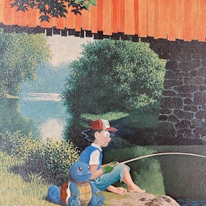 May include: A young person wearing a red baseball cap and blue shirt is fishing from a rock by a river. A blue turtle Pokemon is sitting beside them. The scene is set in a forest with a red wooden bridge in the background.