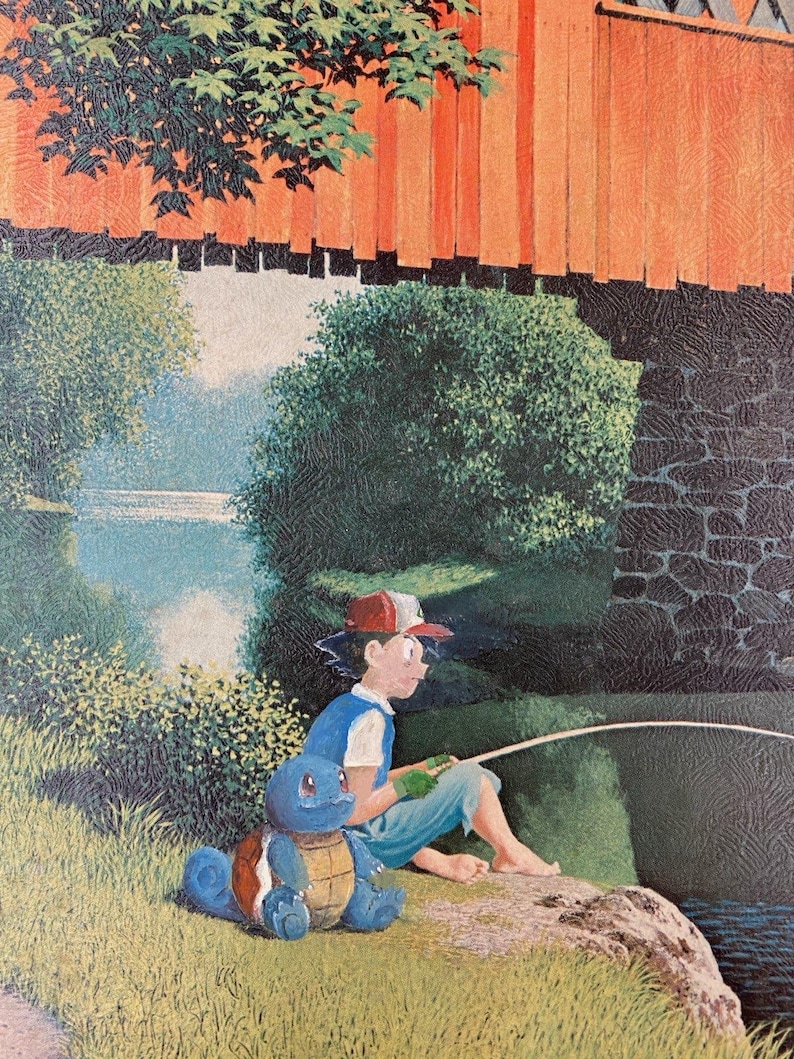 May include: A young person wearing a red baseball cap and blue shirt is fishing from a rock by a river. A blue turtle Pokemon is sitting beside them. The scene is set in a forest with a red wooden bridge in the background.