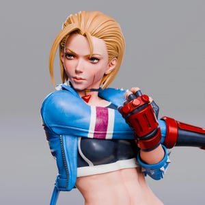 以下が含まれることがあります： ブロンドの髪の女性キャラクターのフィギュア。青いジャケットに白と紫のストライプ、黒いトップス、赤と黒の手袋を着用。このフィギュアは決意した表情をしており、顔に小さな傷跡があります。コレクションアイテムです。