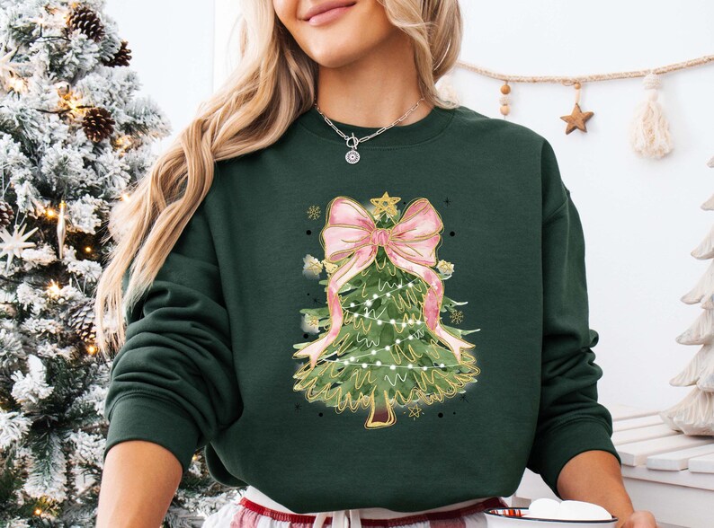 a woman wearing a green christmas sweater with a pink bow