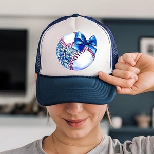 a woman holding a baseball cap with a bow on it