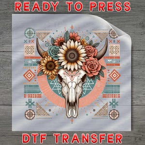 May include: A DTF transfer featuring a bull skull adorned with sunflowers, roses, and succulents. The skull is centered on a gray background with geometric patterns and the words "READY TO PRESS" and "DTF TRANSFER" in red.