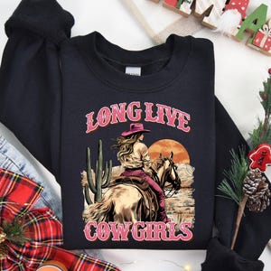 a black long sleeved shirt with a cowboy riding a horse
