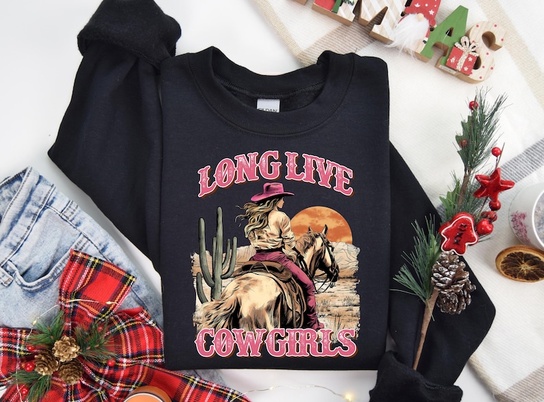 a black long sleeved shirt with a cowboy riding a horse