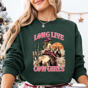 a woman wearing a long live cowgirl sweatshirt