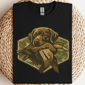 A black t-shirt with a graphic design depicting a dog holding a duck in its mouth.