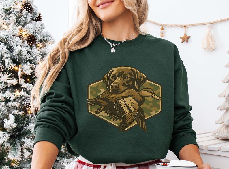 A woman wearing a green sweatshirt with a graphic of a dog holding a bird.