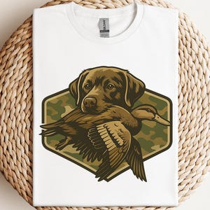 A white t-shirt with a graphic design depicting a dog holding a duck in its mouth.