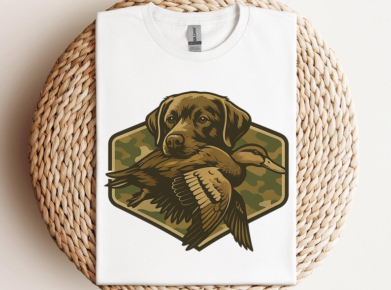 A white t-shirt with a graphic design depicting a dog holding a duck in its mouth.