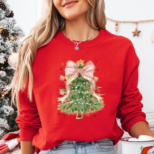 a woman in a red christmas sweater holding a cup of coffee