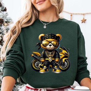 a woman wearing a green sweatshirt with a picture of a teddy bear on it