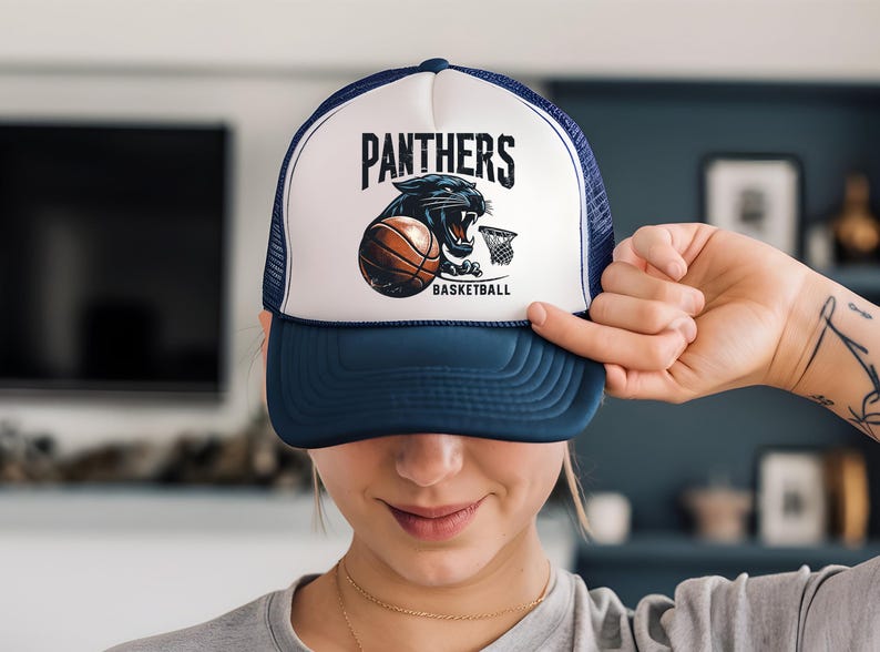 a woman holding up a hat with a panther on it