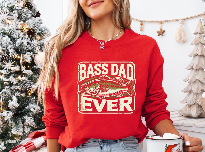 a woman wearing a red bass dad sweatshirt holding a cup of coffee