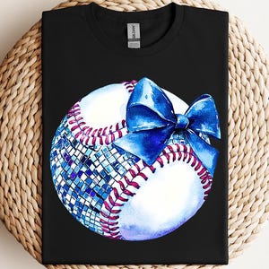 a t - shirt with a baseball and a bow on it