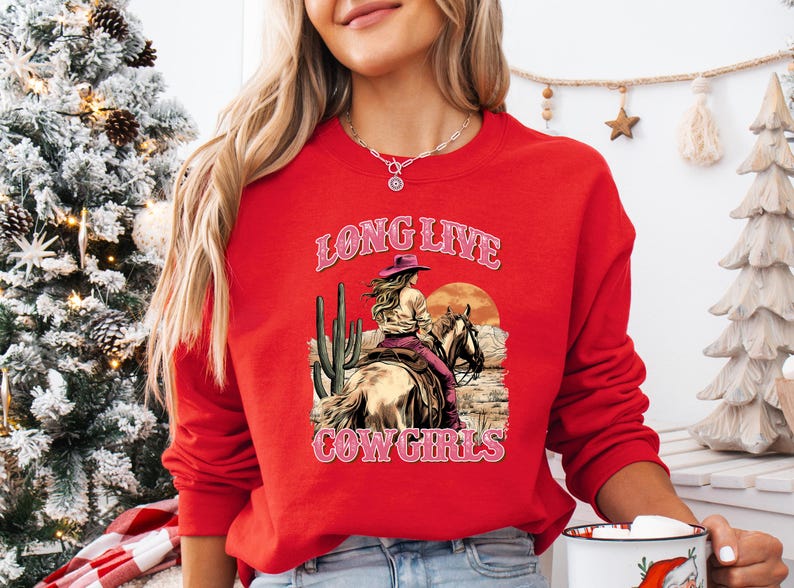 a woman wearing a red long sleeved shirt with a cowboy on it