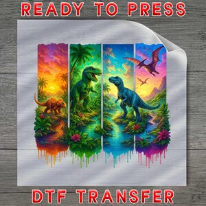 May include: A square DTF transfer sheet featuring four vertical panels of colorful prehistoric dinosaur scenes. The artwork displays a triceratops, a T-Rex, and a pterodactyl in vibrant jungle landscapes with sunset skies, finished with a paint drip effect.