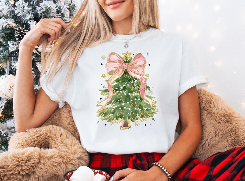 a woman wearing a white shirt with a christmas tree on it