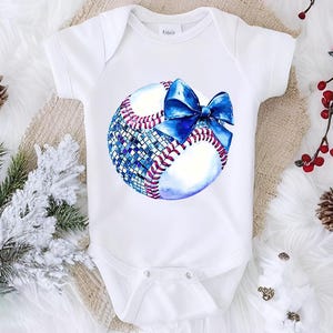 a baby bodysuit with a baseball and a bow on it