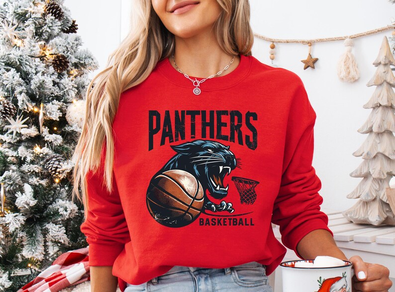 a woman in a red sweatshirt holding a basketball mug