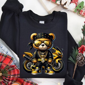 a black shirt with a picture of a bear riding a motorcycle