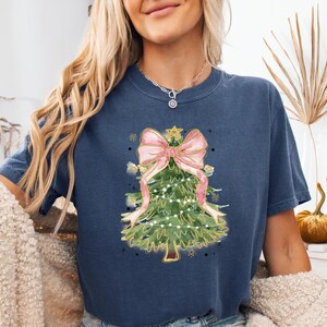 a woman wearing a blue shirt with a christmas tree on it