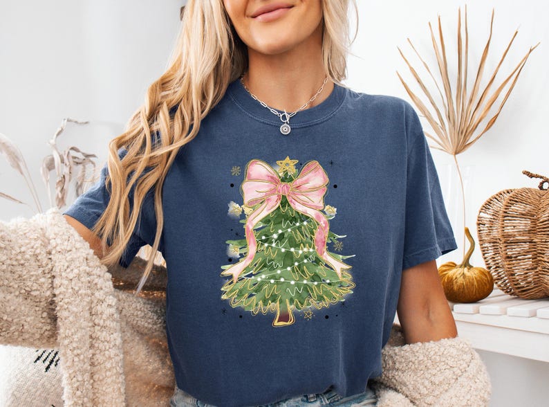 a woman wearing a blue shirt with a christmas tree on it