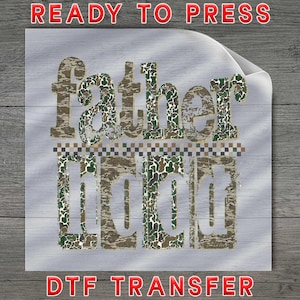 May include: A DTF transfer with the words "fatherhood" in a camouflage pattern. The text "READY TO PRESS" and "DTF TRANSFER" are in red, adding a bold contrast to the design. The background is a light gray wood grain.