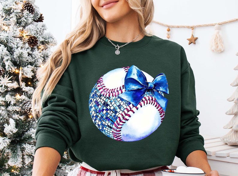a woman wearing a green sweatshirt with a baseball on it