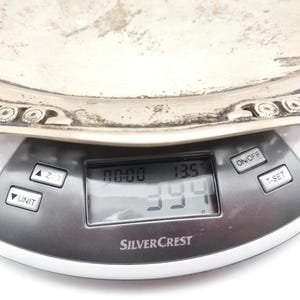 Puede incluir: Una bandeja plateada ornamentada se coloca sobre una b&aacute;scula de cocina digital. La b&aacute;scula muestra un peso de 394 gramos y una temperatura de 13,5 grados Celsius. La b&aacute;scula es de la marca SilverCrest.