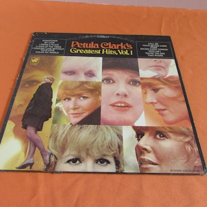 Peut inclure: Pochette d'album vinyle vintage pour Greatest Hits, Vol. 1 de Petula Clark. La couverture présente un collage d'images de Petula Clark, avec le titre de l'album et les titres des chansons imprimés en blanc sur fond noir.