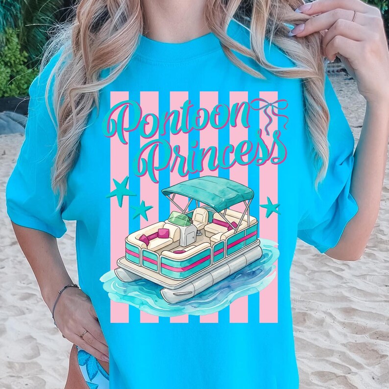 May include: A turquoise t-shirt featuring a graphic of a pontoon boat on water, with the text "Pontoon Princess" in a script font. The design includes pink and white stripes and star accents.