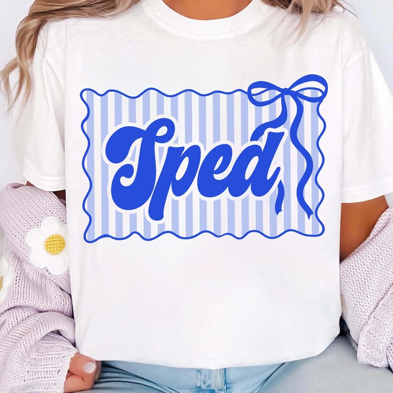 May include: White t-shirt featuring a blue design with the word "Sped" in a bold, cursive font. The design includes a blue striped background and a decorative bow. The shirt is made of a soft material.